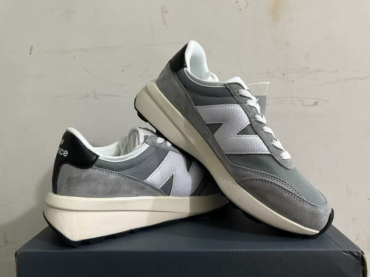 Pair of gray and white New Balance U370 sneakers shown at an angle.