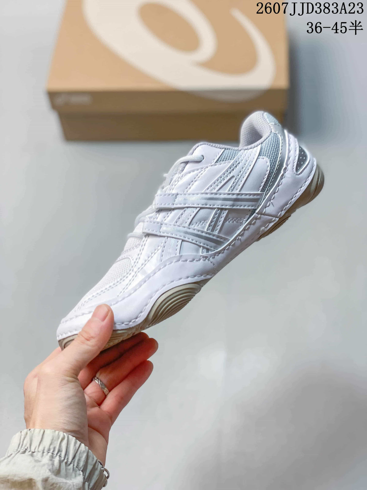 Side view of the white ASICS sneaker showing layered panels, mesh sections and the low-profile outsole.