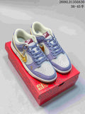 Pair of lavender and light gray Nike SB Dunk Low sneakers with gold accents and a dangling charm on a red horse-themed box.