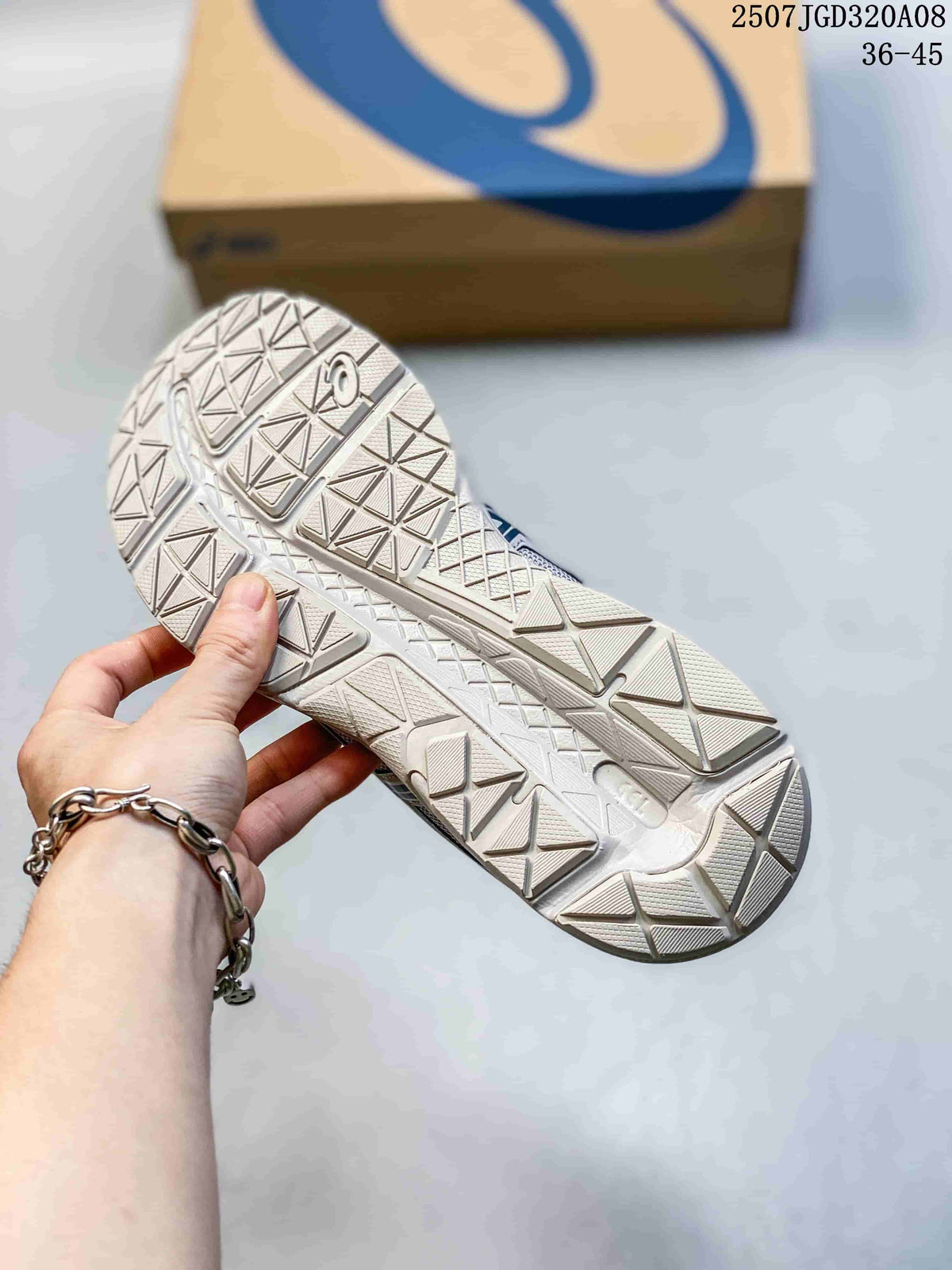 Close view of the geometric patterned outsole on the gray ASICS sneakers.