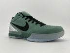 Angled view of the green Nike Kobe basketball shoe with black laces and clear heel accent