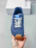 Top view of the blue sneaker showing the rounded toe, white laces, tongue branding, and contrasting panel construction.