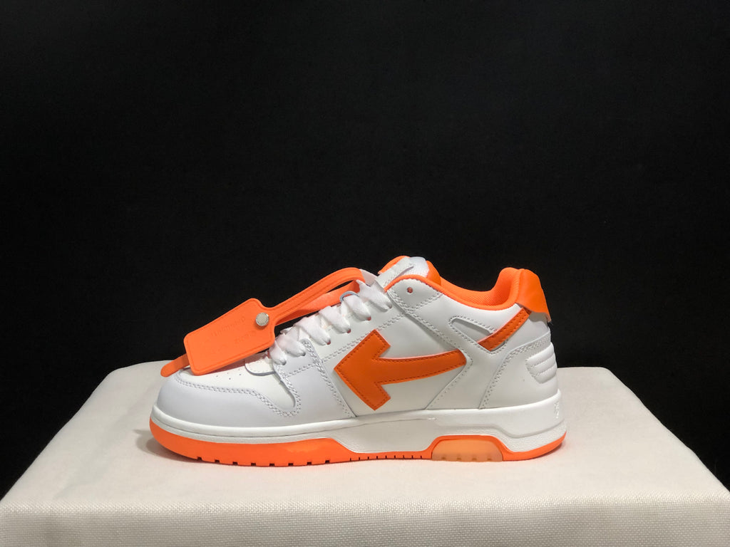 Full side profile showing the low-top silhouette, orange side arrow, white upper, and layered sole.