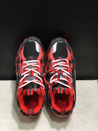 Top view showing the rounded toes, white laces, mesh tongues, and red-and-black upper detailing.