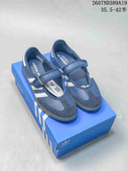Blue adidas Samba Jane sneakers with adjustable straps displayed on a blue shoebox.