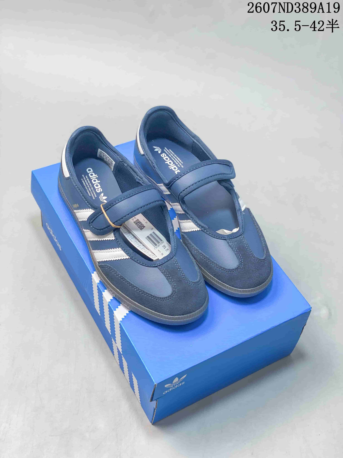 Blue adidas Samba Jane sneakers with adjustable straps displayed on a blue shoebox.