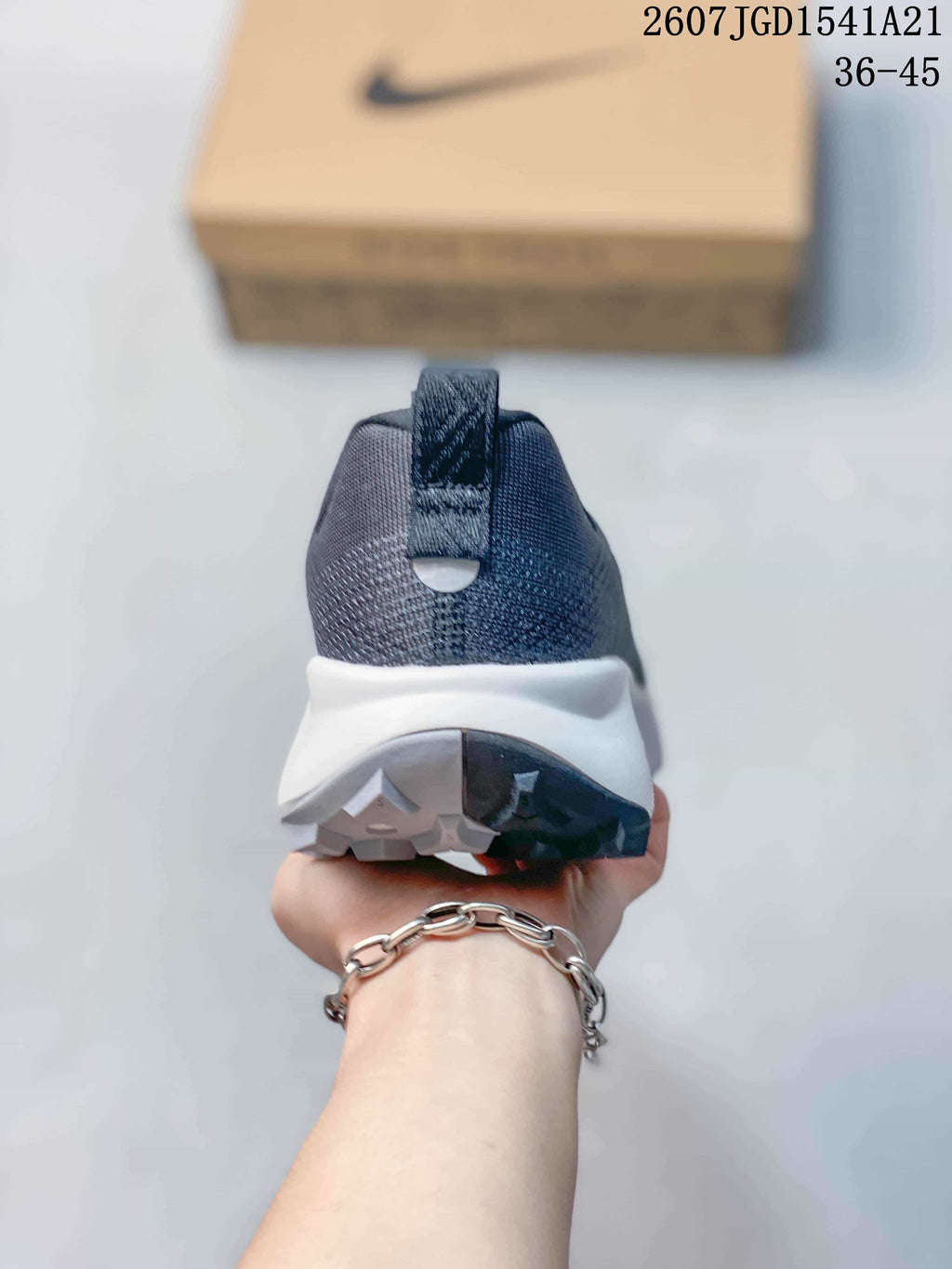 Rear view of the sneaker showing the padded heel collar, heel pull tab, white midsole, and split-color outsole.