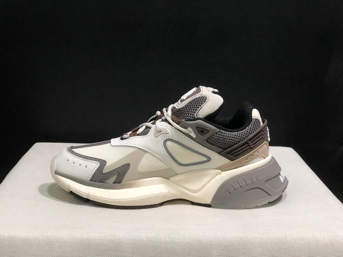Opposite side view of the AMIRI MA Runner sneaker beside its black shoe box.