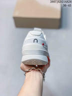Rear view of the white shoe showing the padded heel, On branding, and textured outsole edge.
