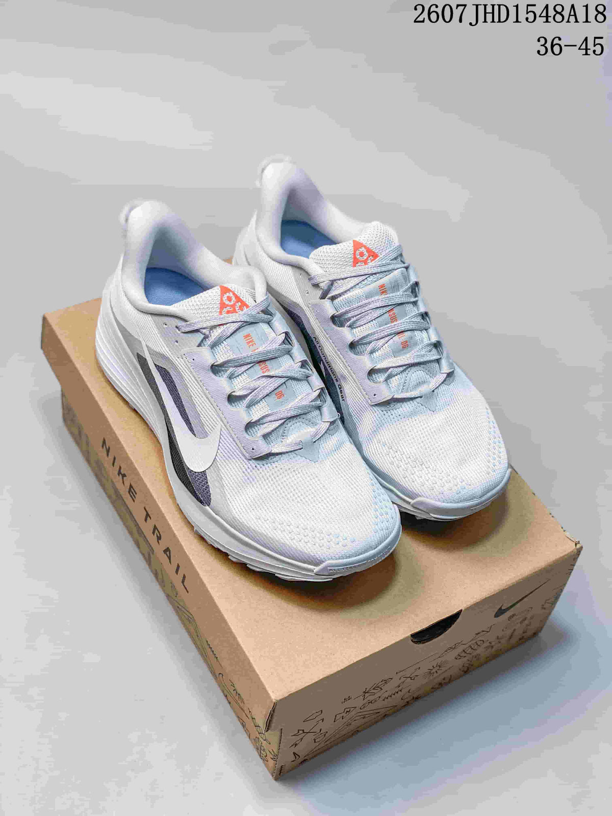 Pair of white and gray Nike low-top sneakers displayed on a shoebox, with the source size range 36–45 visible above.