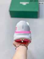 Rear view of the white sneaker with a pink heel accent and split outsole.