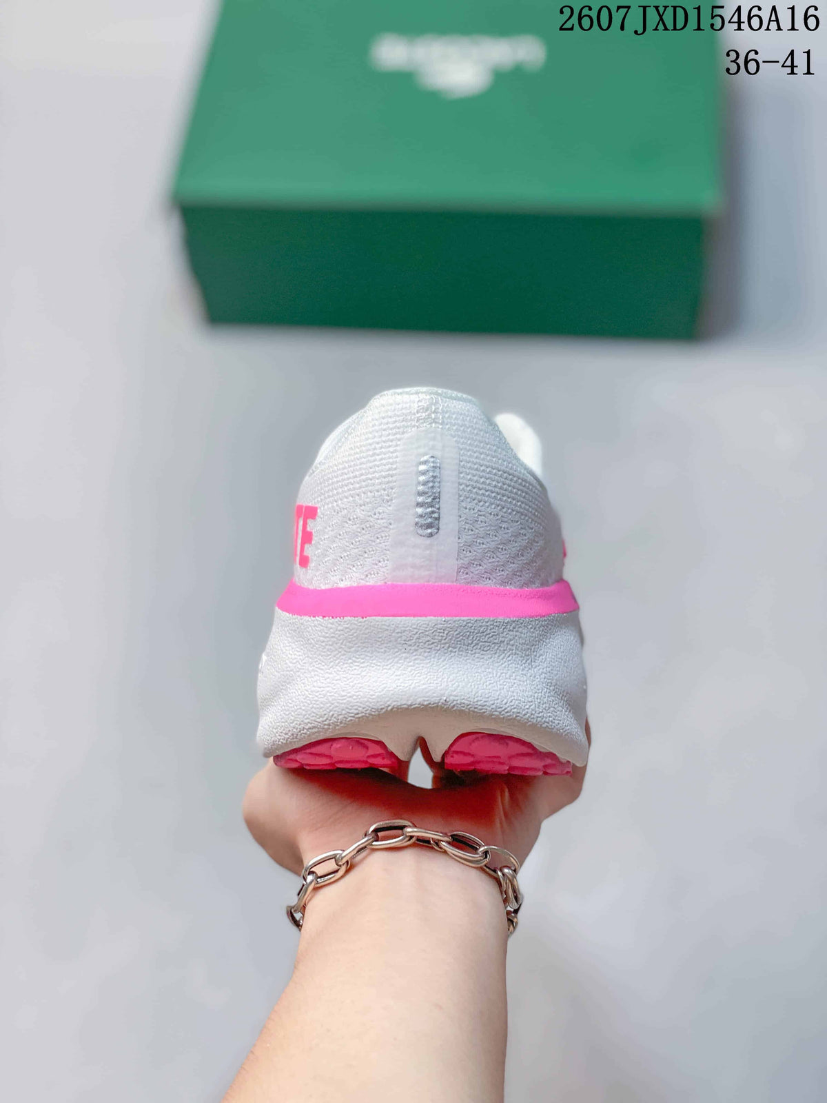 Rear view of the white sneaker with a pink heel accent and split outsole.