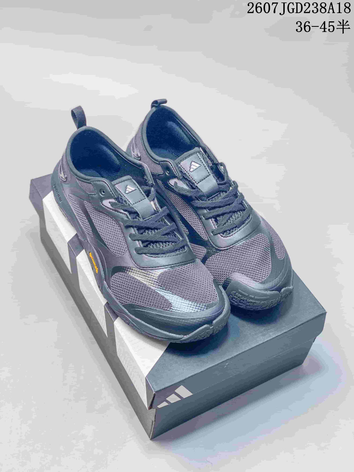 Pair of dark gray adidas FOS GROUNDFLOW sneakers displayed on an adidas shoe box.
