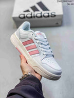 Angled side view of the white and pink adidas Entrap sneaker with its layered upper and textured outsole.