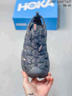 Top view of a black HOKA Hopara OG sandal showing the toggle lace system, protective toe area and open side panels.