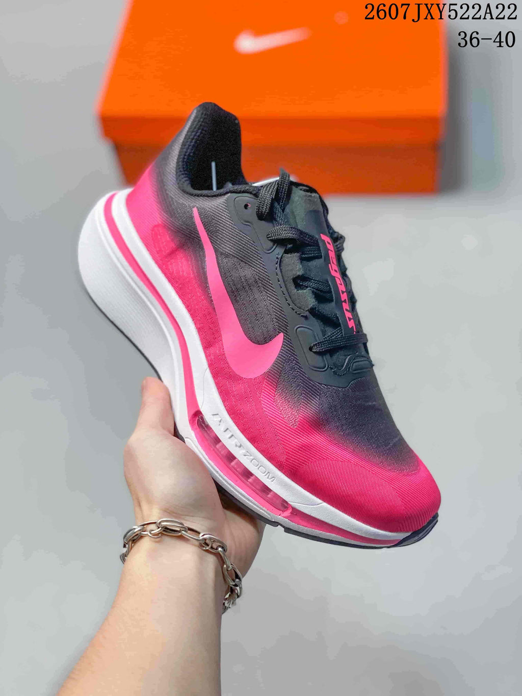 Angled side view showing the black and pink upper, pink Nike Swoosh, and white layered midsole.