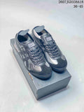 Pair of gray and black Onitsuka Tiger low-top sneakers displayed on a shoebox.