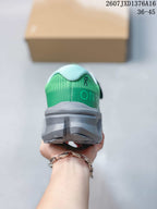 Rear view of the green sneaker showing the padded collar, heel branding, and gray sole.