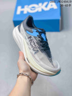 Angled side view showing the gray mesh upper, black laces, blue branding details, and thick sculpted white sole.