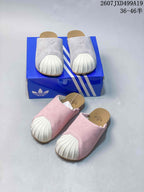 Grey and pink pairs of adidas Adimule mule slides shown together with a blue shoebox.