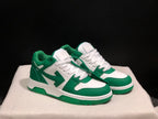 Front three-quarter view of the green and white sneaker pair with white laces and green outsoles.