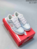 Pair of white, pale blue, and pink low-top sneakers shown on a red shoebox