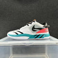 White, black, and turquoise Nike low-top sneaker with mesh-look panels and a pink-red heel accent.