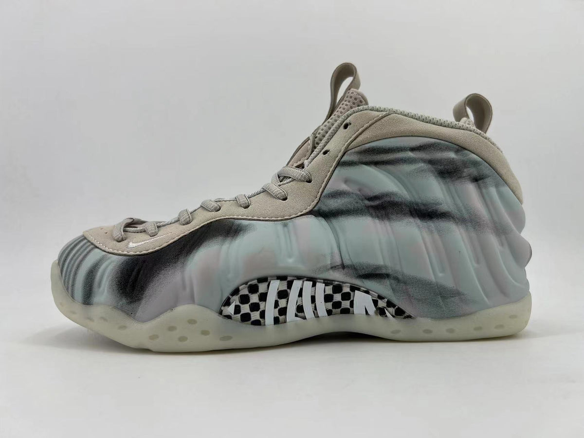 Side view of a grey and black marbled Nike Air Foamposite One high-top sneaker with a patterned midfoot panel.
