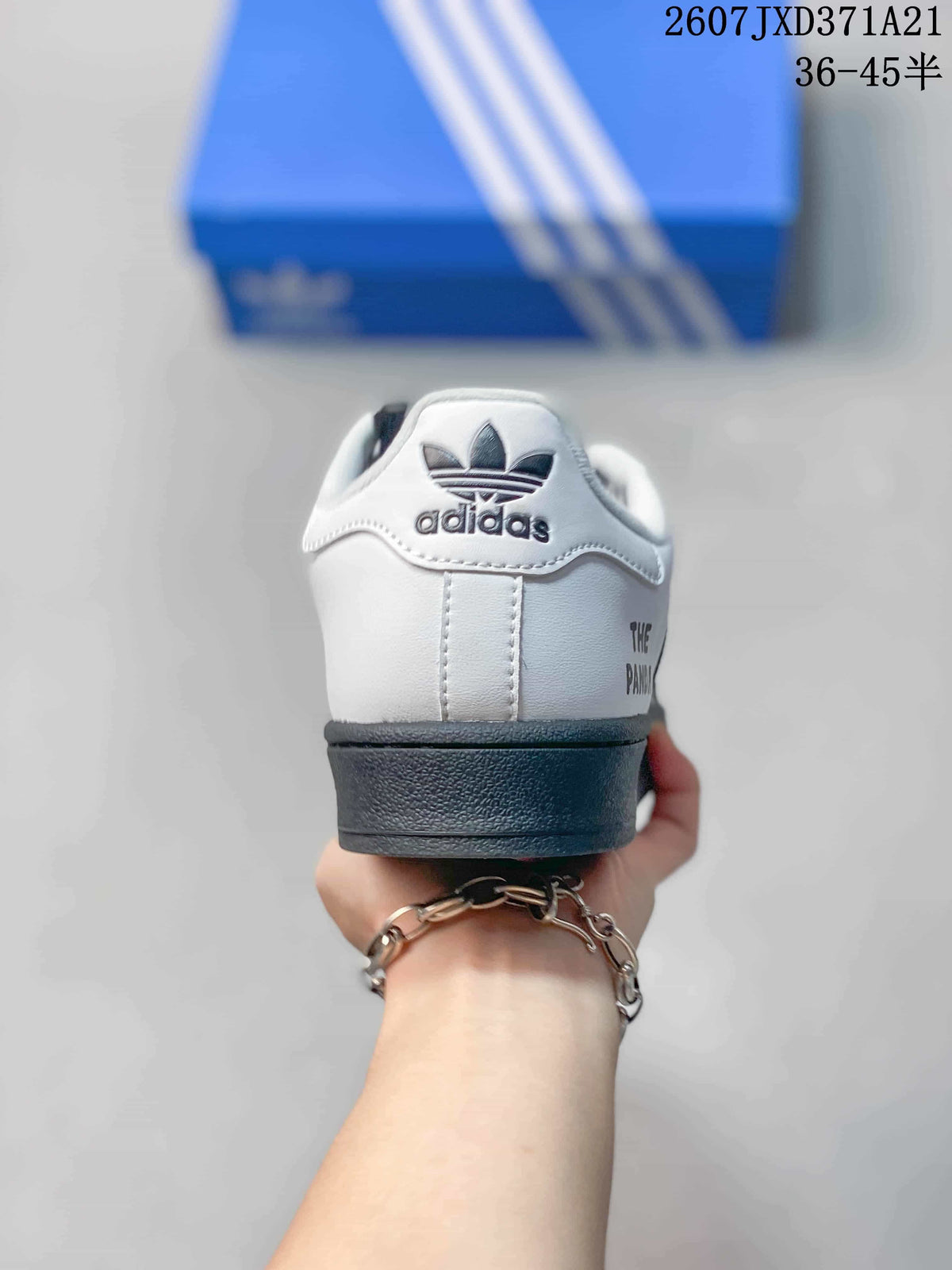 Rear view showing the white heel, Trefoil branding, black heel detail, and printed side text.