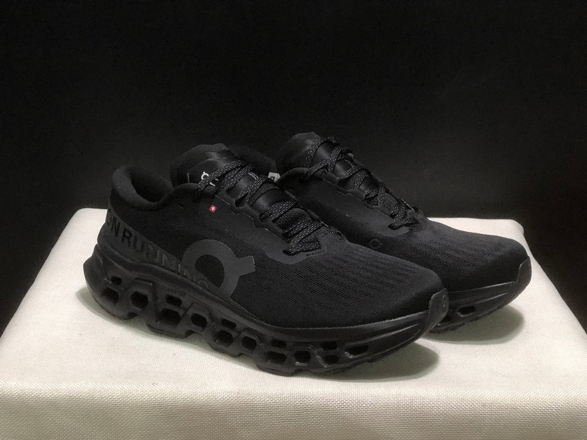 Three-quarter front view of the black lace-up sneakers with textured uppers and sculpted outsoles.