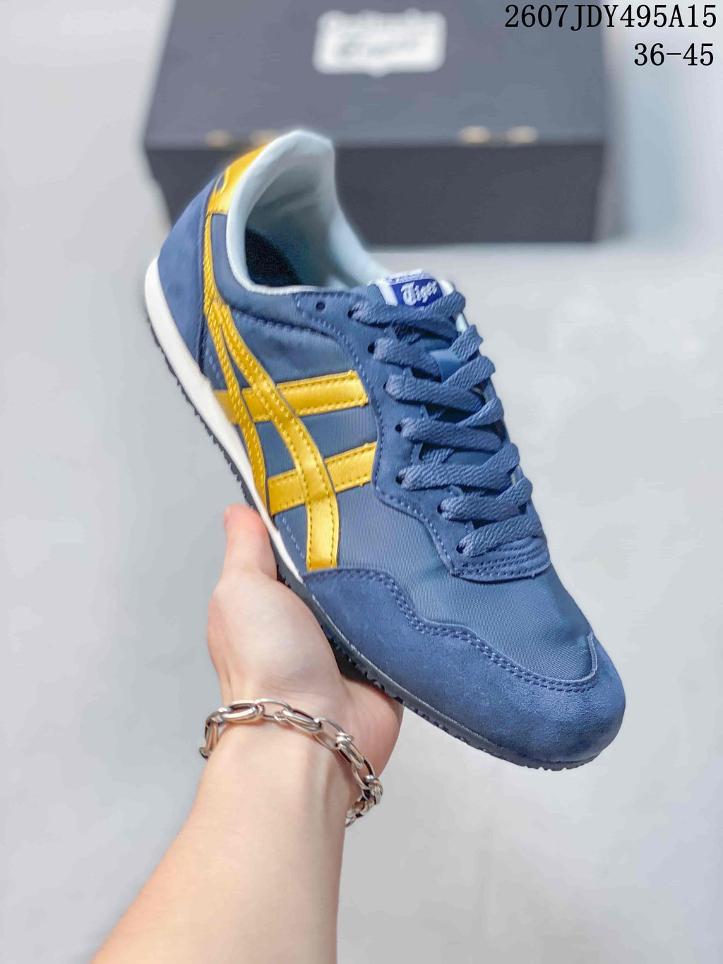 Angled close view of the blue and yellow sneaker showing its lace-up construction, contrasting side stripes, white midsole, and dark outsole; image text shows size range 36-45.