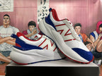 Pair of white New Balance sneakers with red and navy accents, shown from the side.