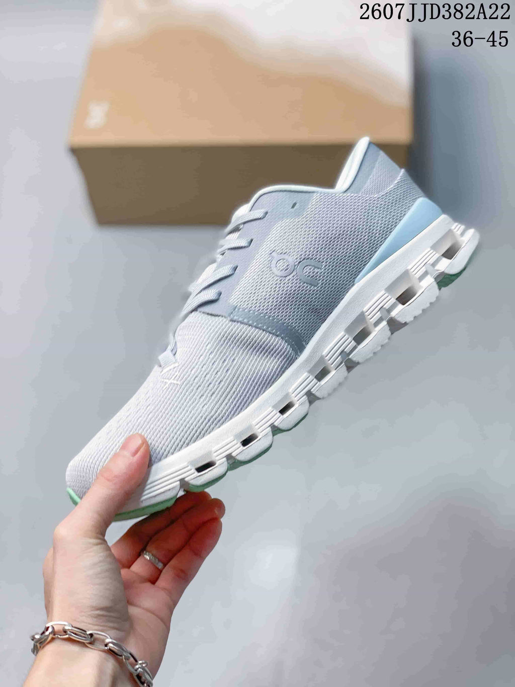 Side view of the gray low-top sneaker showing the textured upper, On branding and segmented outsole.