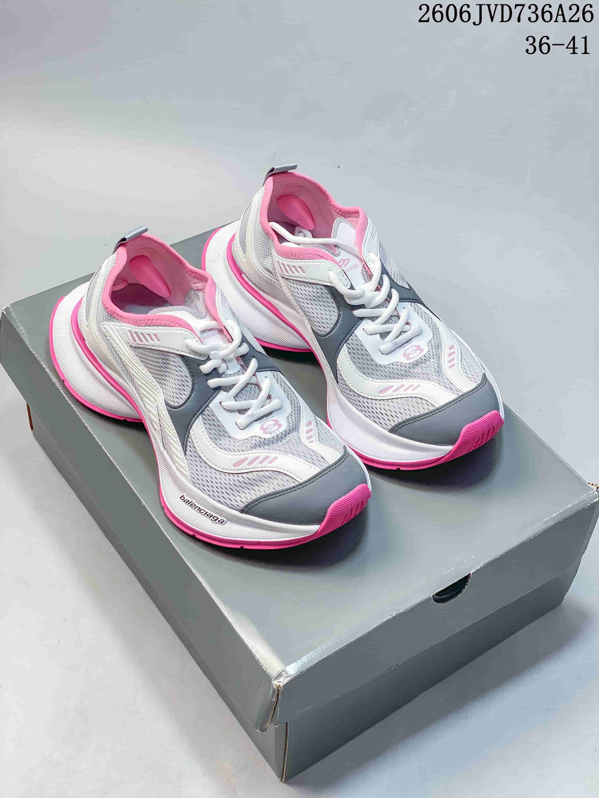 Pair of gray, white, and pink Balenciaga Circuit-style sneakers on a gray shoe box