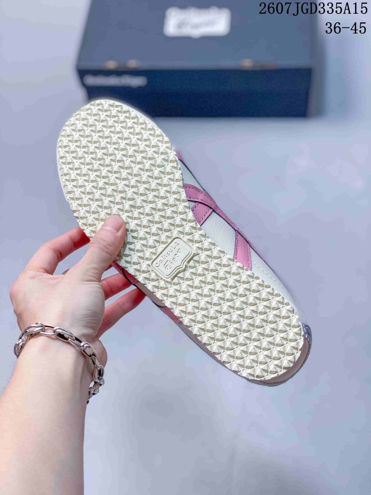 Close view of the sneaker outsole showing a repeating textured traction pattern and molded branding.