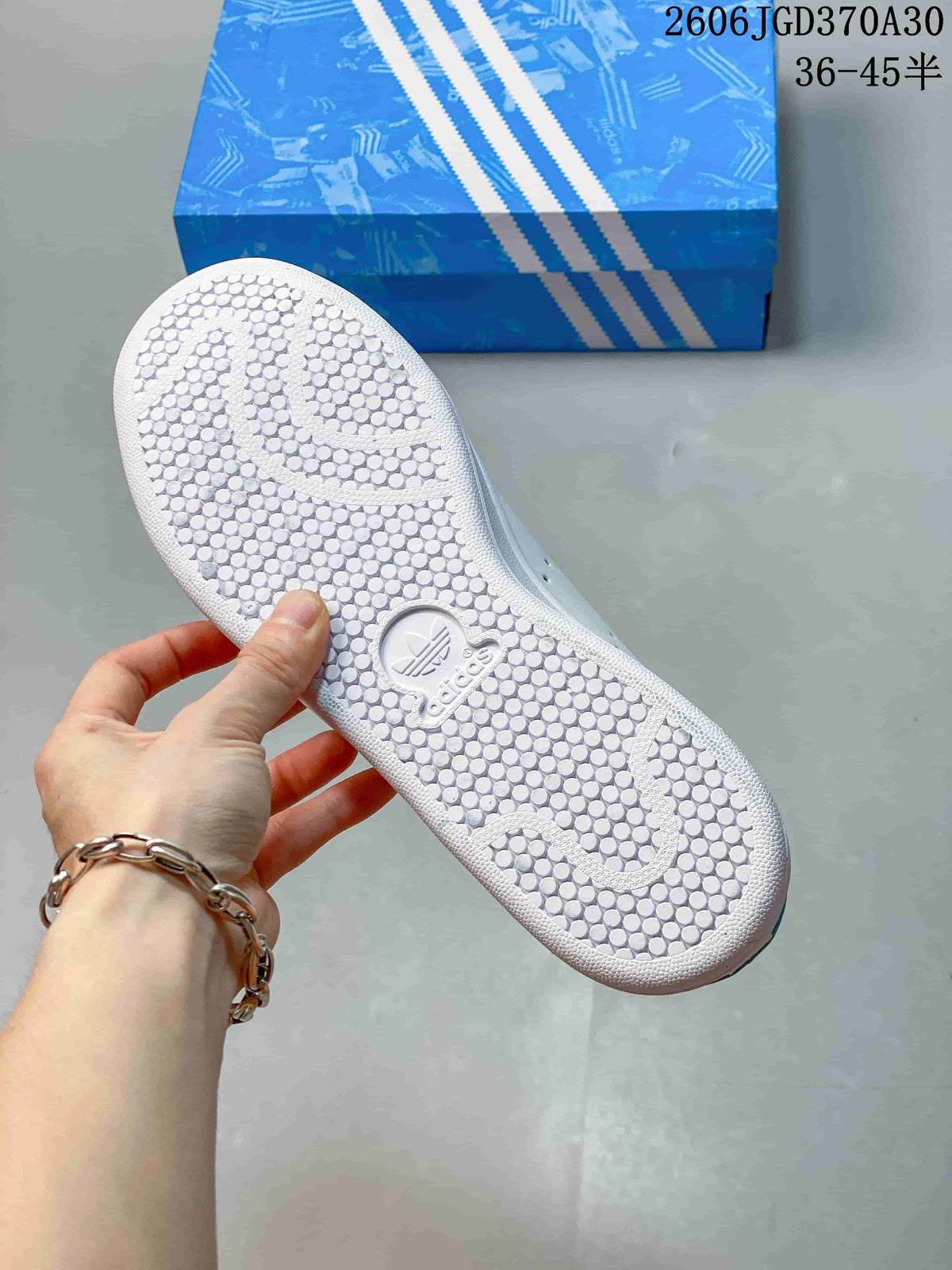 Close-up of the white patterned outsole and blue shoe box