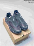 Pair of dark gray DESCENTE DUALIS PRIMER slip-on sneakers displayed on a shoe box.