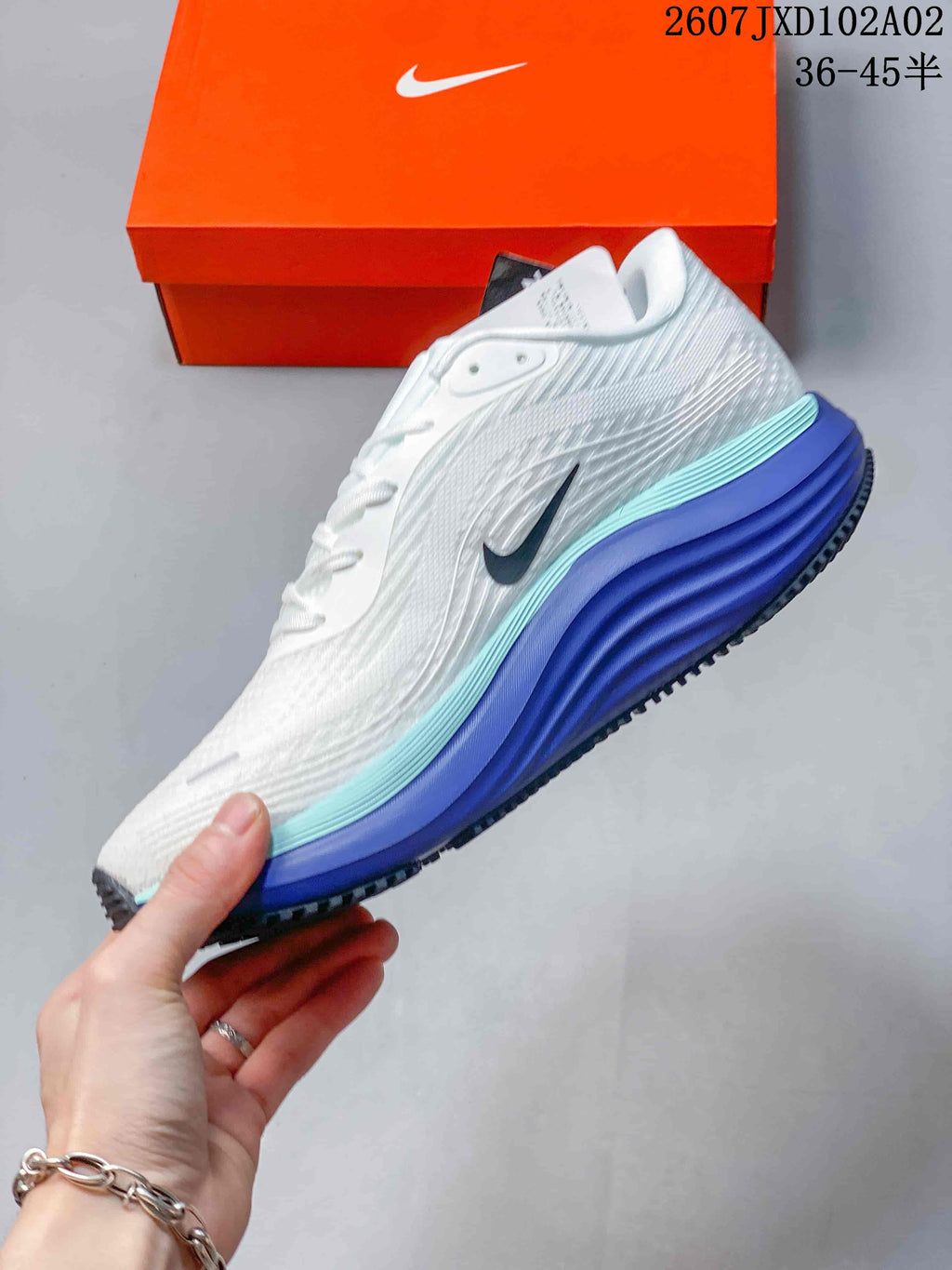 Side view of the white running shoe with dark Swoosh and blue and aqua midsole accents