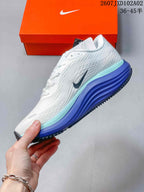 Side view of the white running shoe with dark Swoosh and blue and aqua midsole accents
