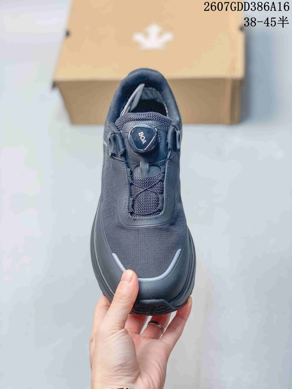 Top view of the black sneaker showing the textured upper, BOA-style dial, and rounded toe design.