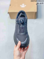 Top view of the black sneaker showing the textured upper, BOA-style dial, and rounded toe design.