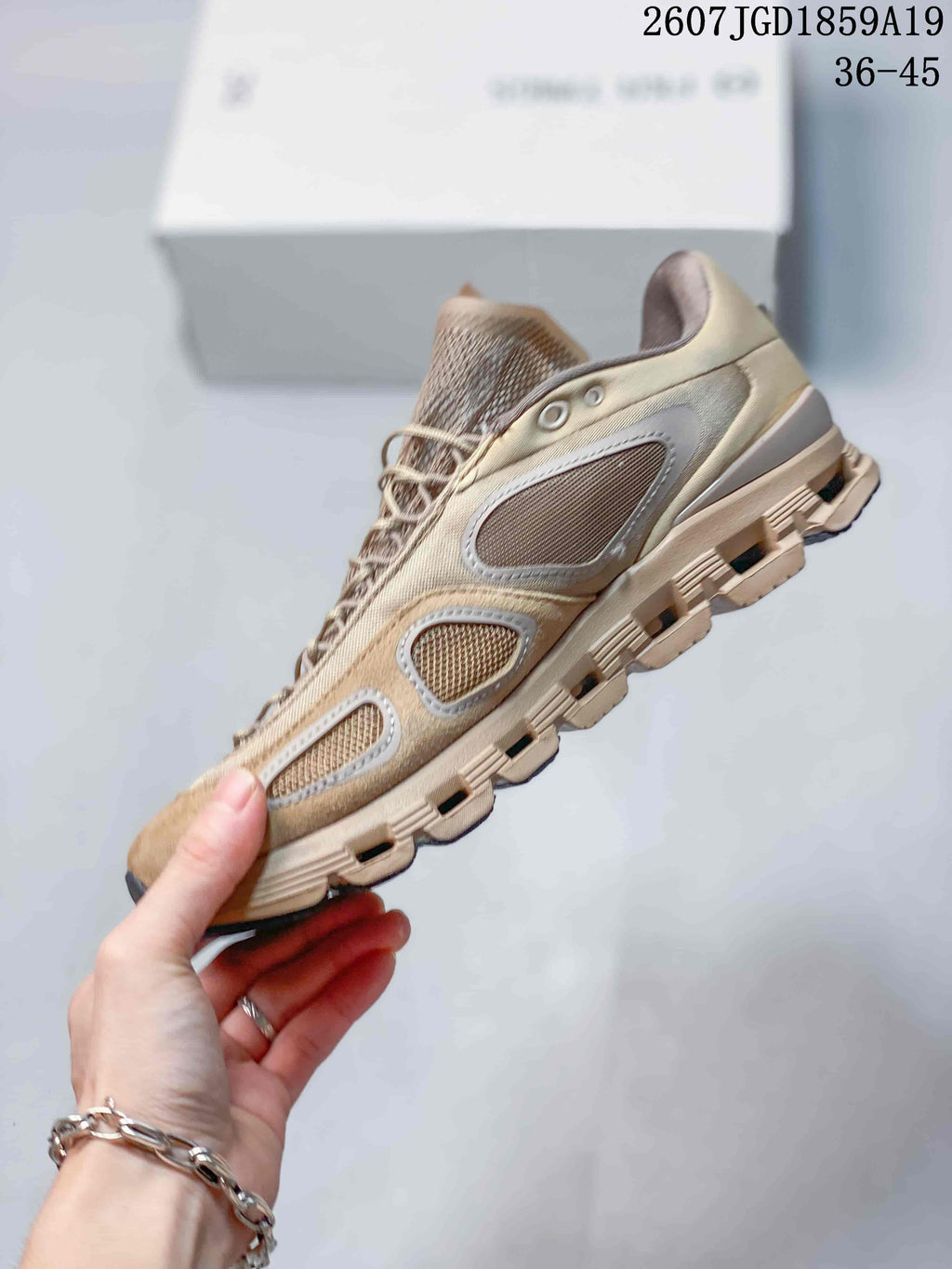 Side profile of a beige sneaker showing mesh panels, tonal overlays, lace eyelets, and the segmented sole.