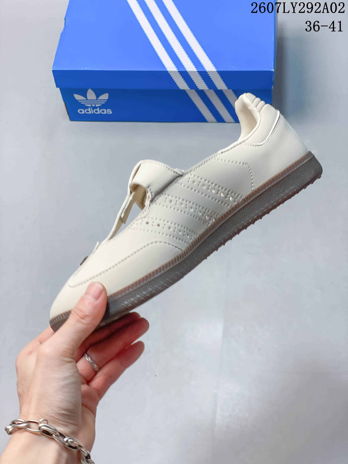 Side profile of the cream Samba Jane sneaker showing perforated detailing, layered panels, and the gum-colored sole.