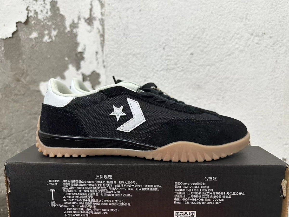 Side view showing the white star-and-chevron emblem on a black Converse sneaker.