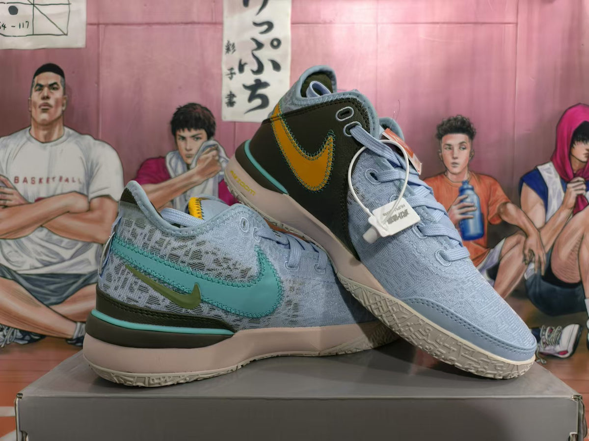 Pair of light blue Nike basketball shoes showing teal and yellow accents and textured outsoles