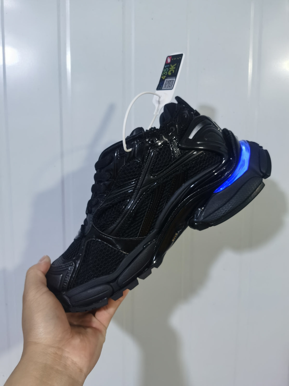 Rear and lateral view of the black Puma Runner LED sneaker with a blue illuminated heel accent and textured outsole.
