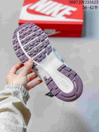 Close-up of the textured outsole on a silver and white sneaker, with the red Nike shoebox in the background; size range 36–42.5 is visible.