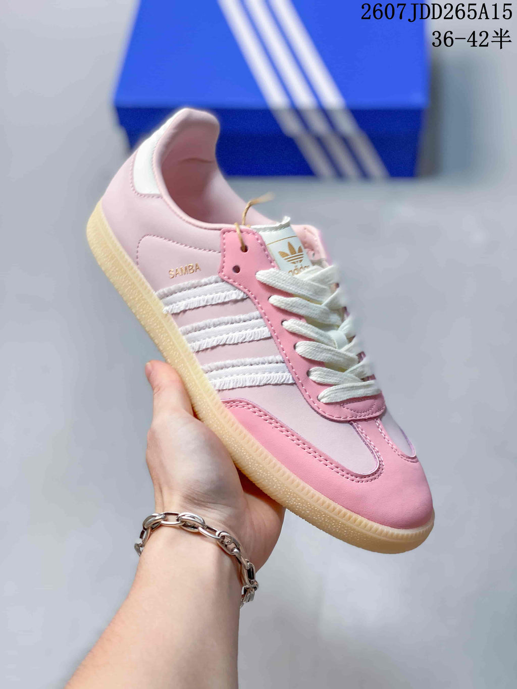 Close side view of a pink and white adidas Samba sneaker showing white stripe detailing, lace-up construction, and a gum-colored sole.