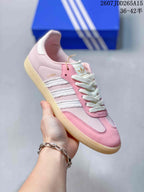 Close side view of a pink and white adidas Samba sneaker showing white stripe detailing, lace-up construction, and a gum-colored sole.