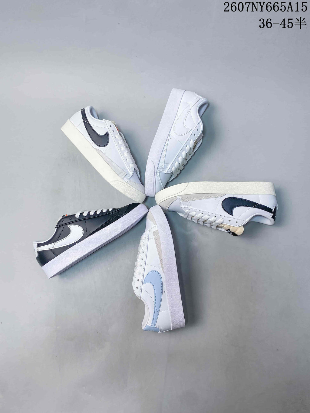 Overhead arrangement showing several Nike low-top sneakers in white, dark and light blue color combinations.